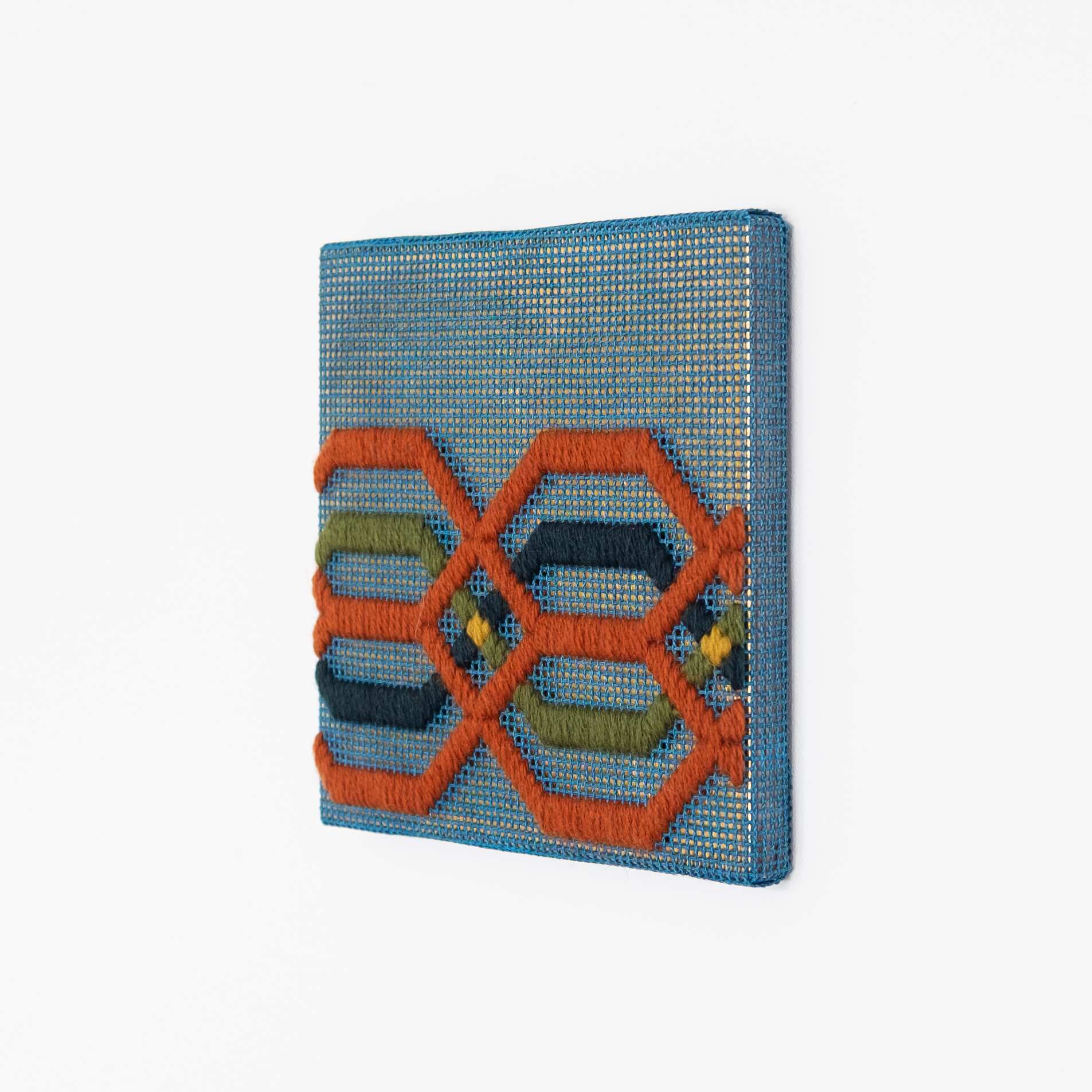 Border fragment [rust-green-blue on blue], Hand-embroidered wool thread and acrylic paint on canvas over gilded panel, 2021